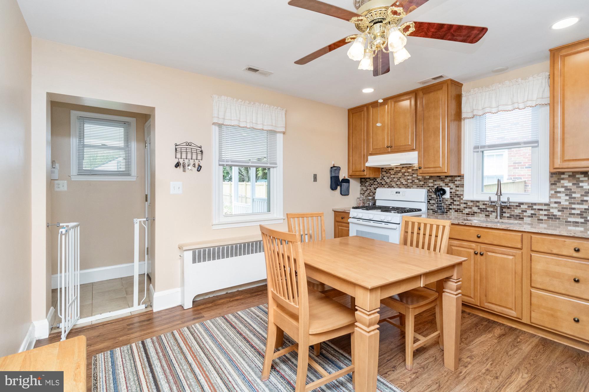 4305 Fullerton Avenue Baltimore, MD 21206 - Photo 10 of 36 a kitchen with stainless steel appliances granite countertop a dining table chairs and white cabinets