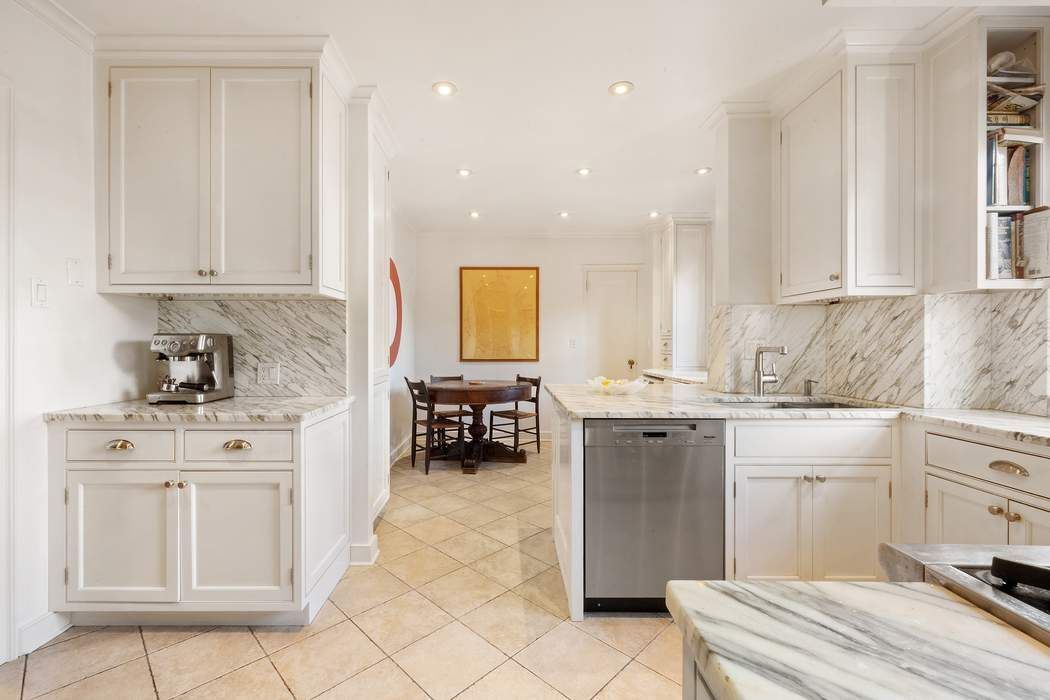 215 East 72nd Street, Unit 9W Manhattan, NY 10021 - Photo 10 of 15 a kitchen with a sink stove and cabinets