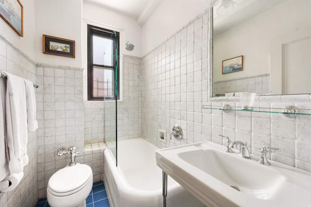 215 East 72nd Street, Unit 9W Manhattan, NY 10021 - Photo 7 of 15 a bathroom with a sink toilet and shower