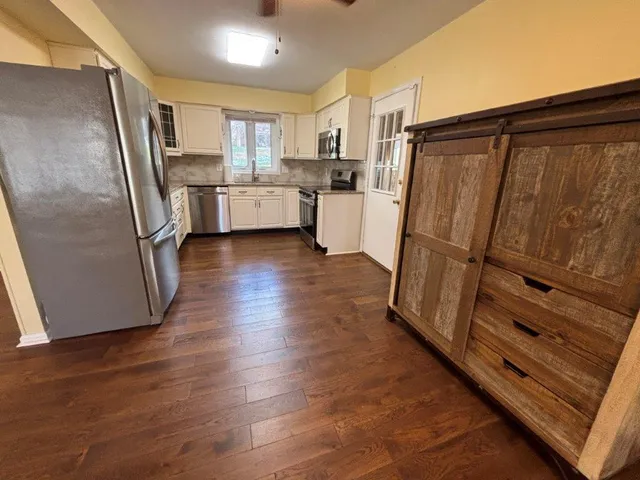 a kitchen with stainless steel appliances a stove a microwave and sink