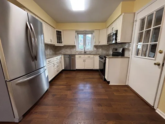 a view of a refrigerator in kitchen and wooden floor