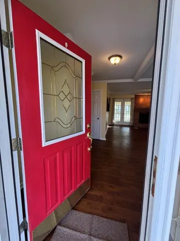 an empty room with wooden floor fireplace and a window