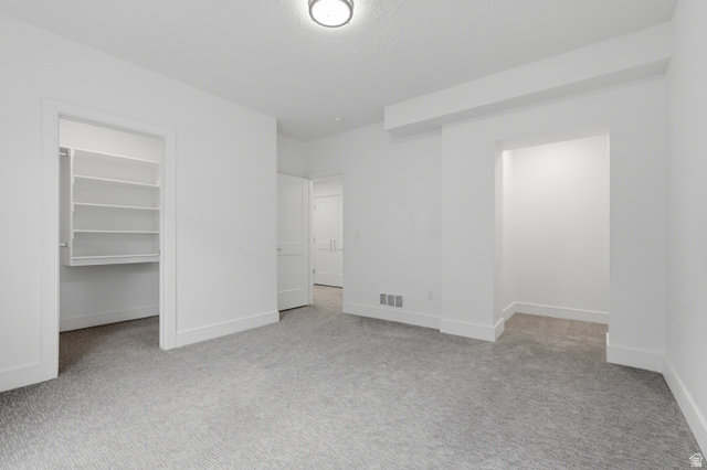 653 East Vandalay Lane Draper, UT 84020 - Photo 39 of 61 Spacious room featuring light-colored carpeting, white walls, and a recessed closet with built-in shelving