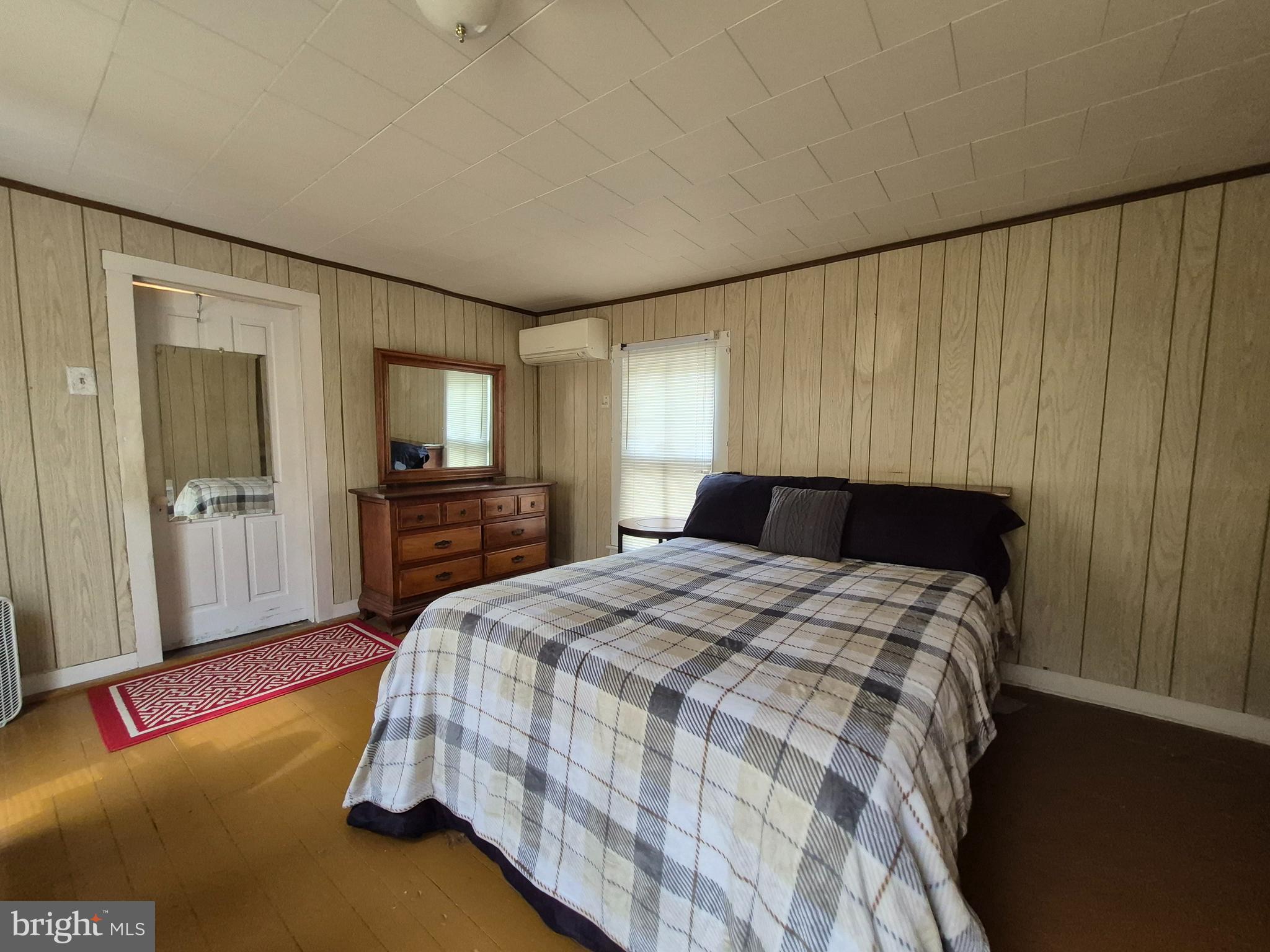 715 Main Street Sharptown, MD 21861 - Photo 21 of 36 a bed sitting in a spacious bedroom next to a window and a flat screen tv