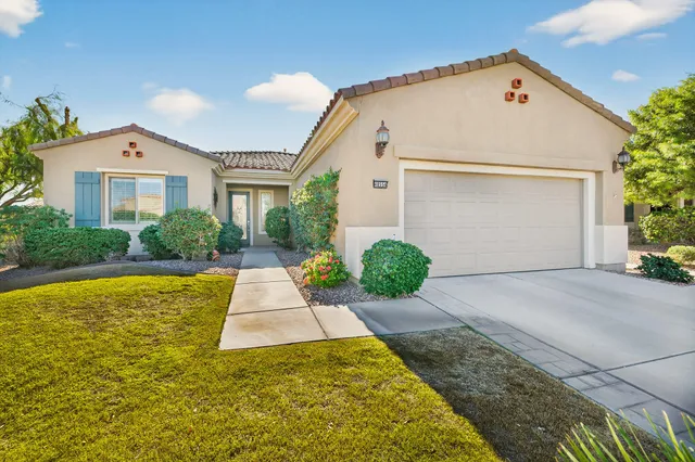 a front view of a multi story residential apartment building with yard and flowers