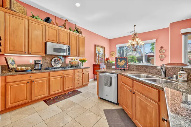 a kitchen with stainless steel appliances a sink cabinets and a window