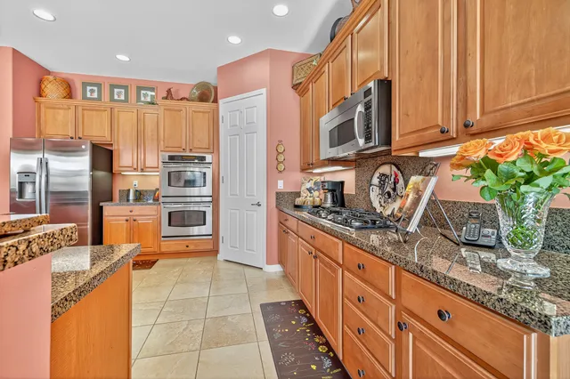 a kitchen with stainless steel appliances granite countertop a stove a sink and a refrigerator