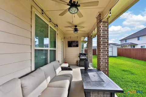 a view of a porch with furniture and a yard