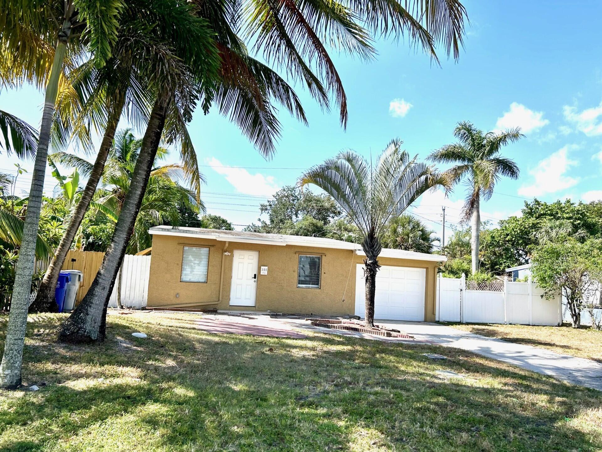 a view of a house with a yard and a palm tree