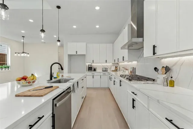a kitchen filled with white cabinets appliances and a sink
