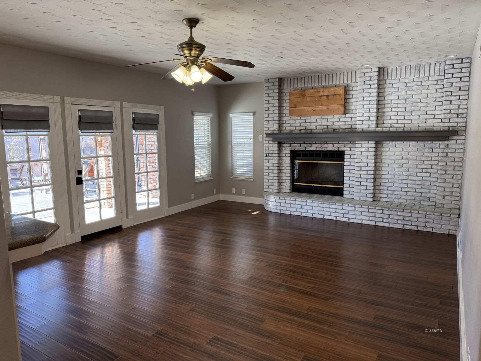 413 Laurkris Court Ridgecrest, CA 93555 - Photo 9 of 48 a view of a livingroom with wooden floor a fireplace and windows