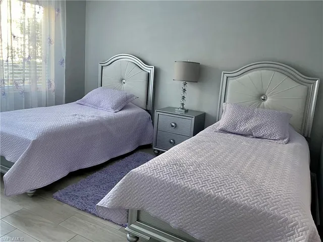 a bedroom with two beds and large window