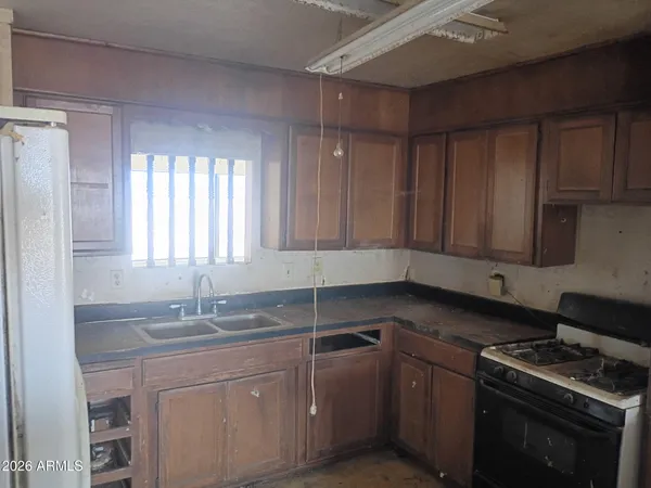 a kitchen with a sink cabinets appliances and a window