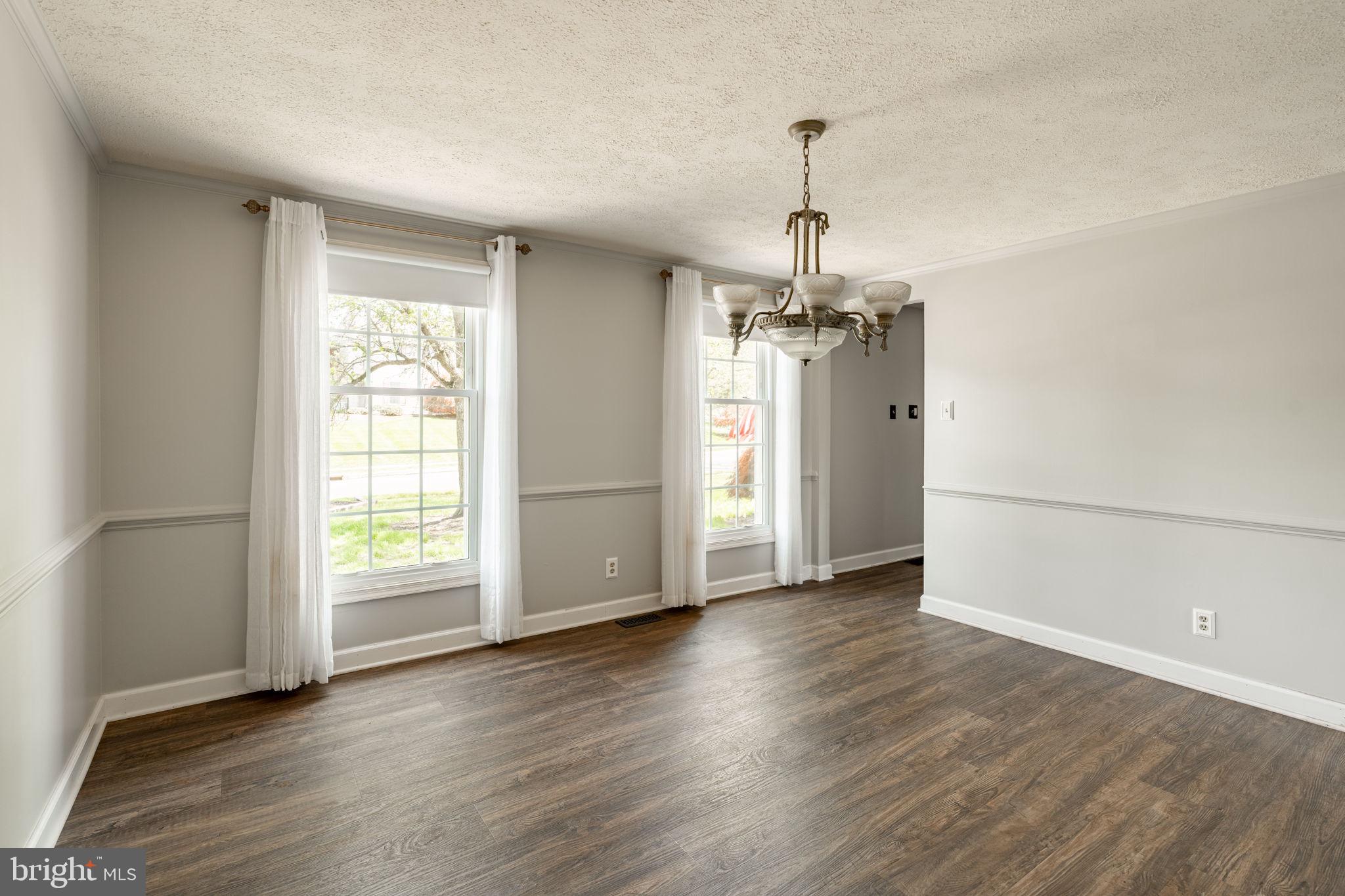 2072 Spring Valley Road Lansdale, PA 19446 - Photo 11 of 48 an empty room with wooden floor chandelier and windows