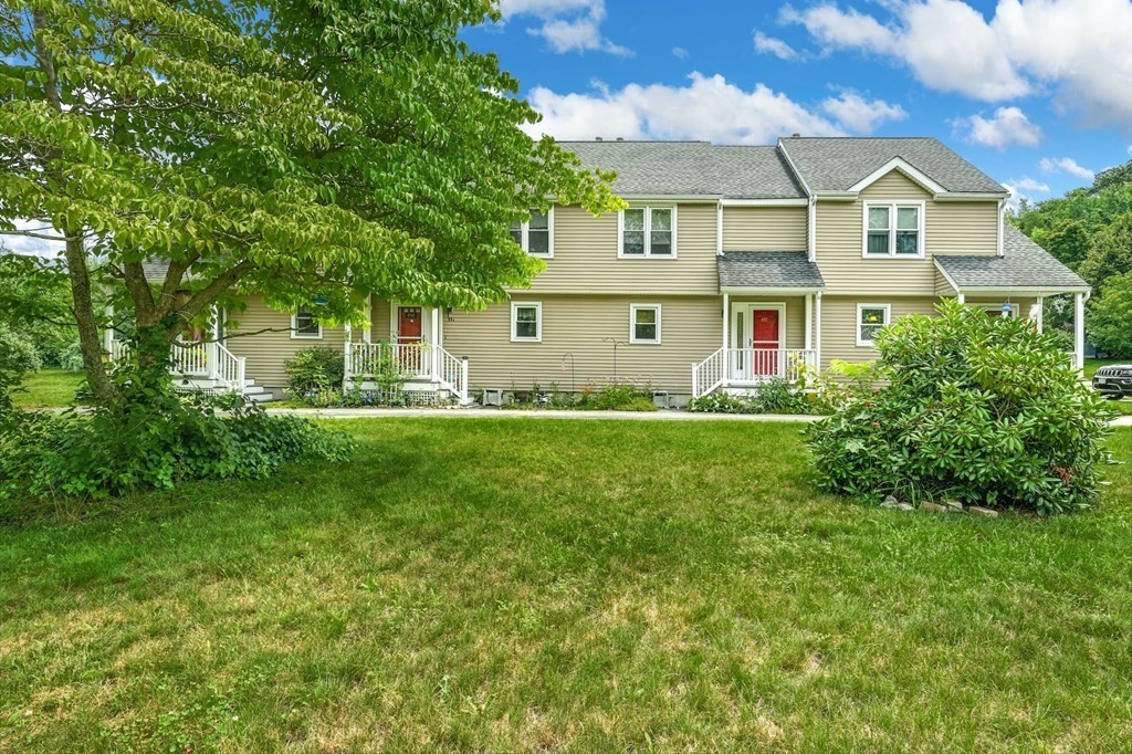 45 Boston Road, Unit C Sutton, MA 01590 - Photo 1 of 35 a front view of a house with a garden and trees