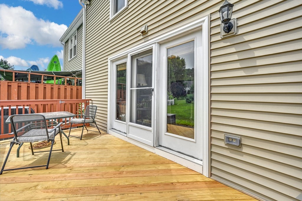 45 Boston Road, Unit C Sutton, MA 01590 - Photo 27 of 35 a view of a patio with table and chairs with wooden floor and fence