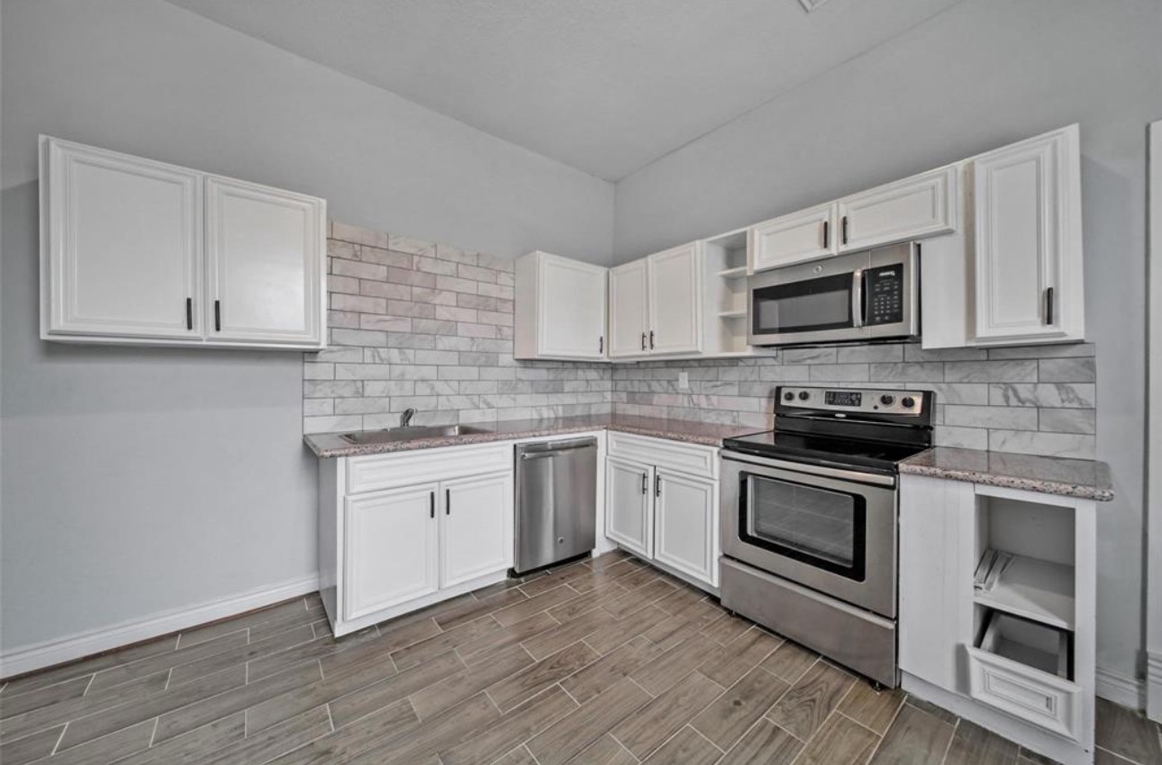 2205 Sumpter Street Houston, TX 77026 - Photo 7 of 7 a kitchen with granite countertop white cabinets stainless steel appliances and a sink