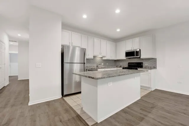 a kitchen with stainless steel appliances granite countertop a refrigerator stove a sink and a microwave