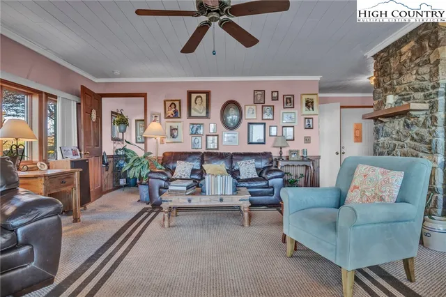 a living room with furniture a flat screen tv and a floor to ceiling window