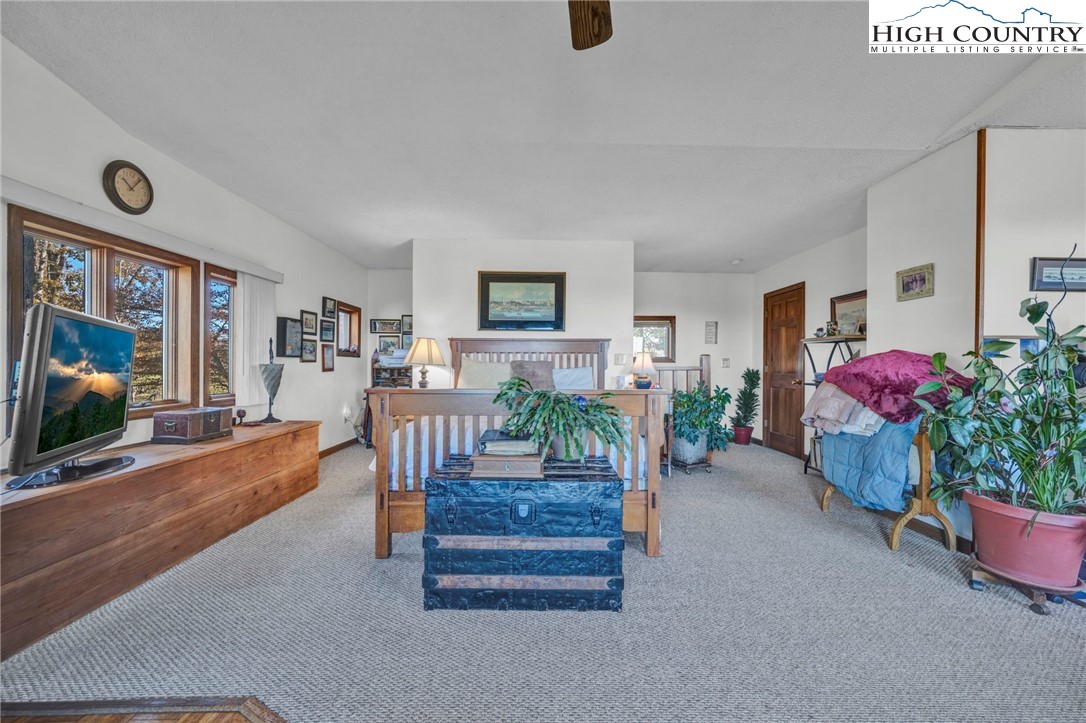 540 Mountain Farm Road Boone, NC 28607 - Photo 31 of 46 a living room with furniture a flat screen tv and a floor to ceiling window