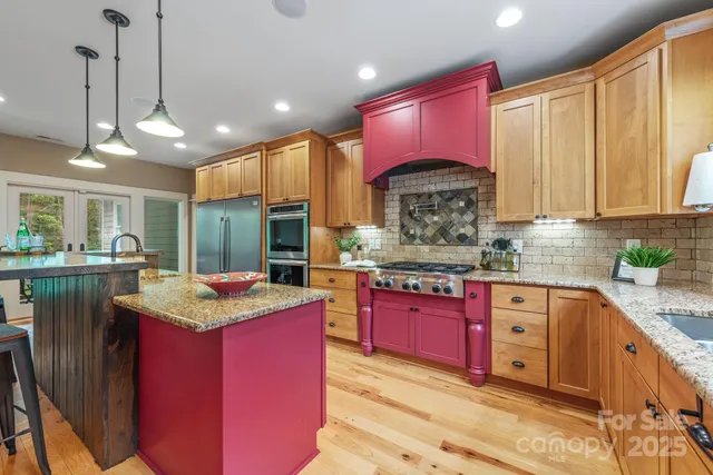 a kitchen with stainless steel appliances kitchen island granite countertop a kitchen island a stove a sink a dining table and chairs