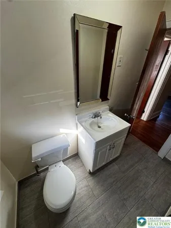 a bathroom with a toilet mirror and sink