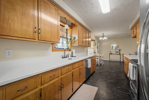a large kitchen with a sink and dishwasher a oven with wooden floors