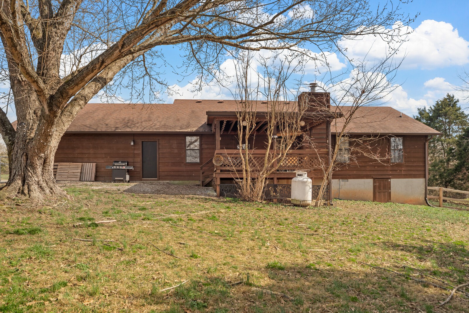 2427 Toler Road Woodlawn, TN 37191 - Photo 40 of 48 a view of a house with a large tree and a yard