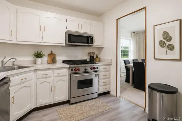 a kitchen with cabinets stainless steel appliances and a sink