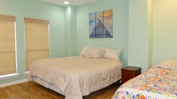 a bedroom with two beds and painting on the wall