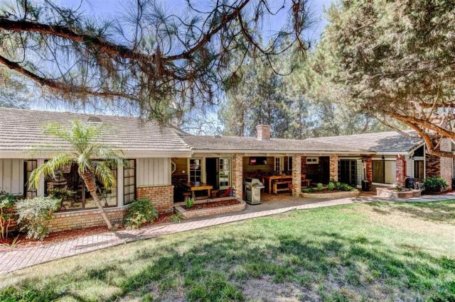 a view of a chairs and tables in patio and a backyard
