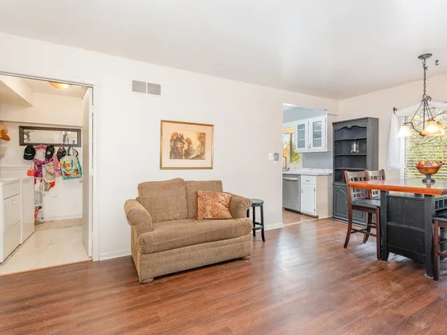 a living room with furniture and painting on the wall next to a window