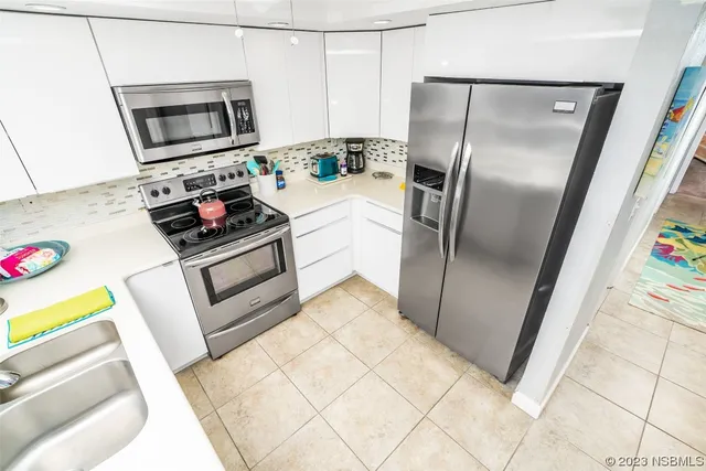 a kitchen with stainless steel appliances a refrigerator sink and microwave