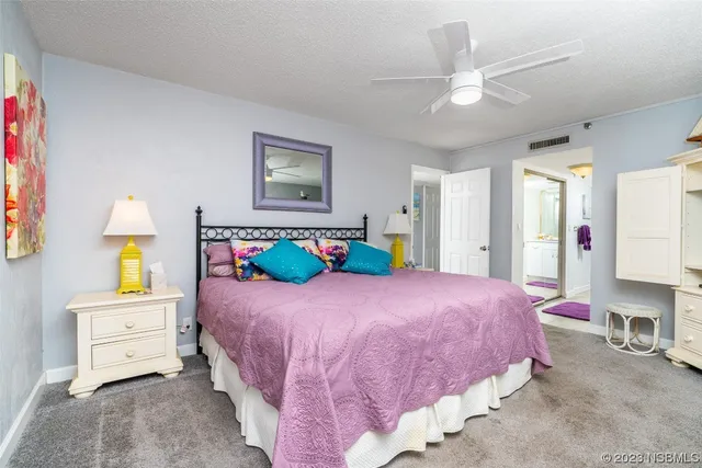 a bedroom with a bed a chandelier and a couch