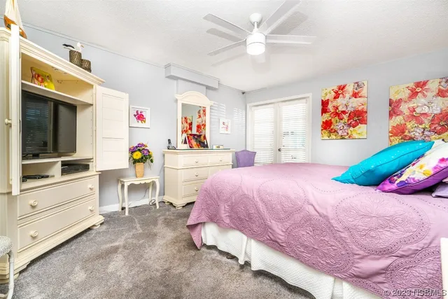 a bedroom with a bed a dresser and a chandelier