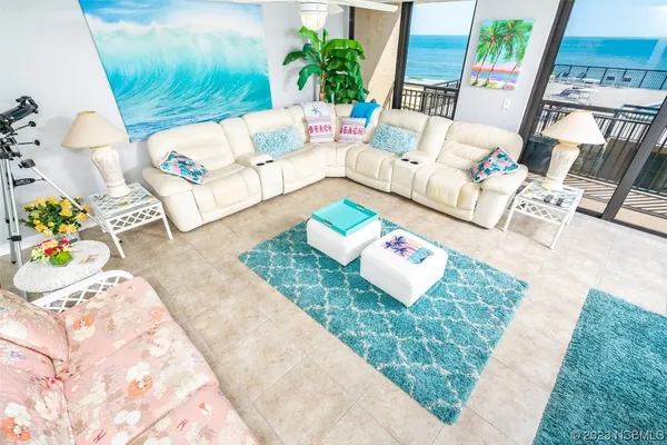 a living room with patio furniture and a rug