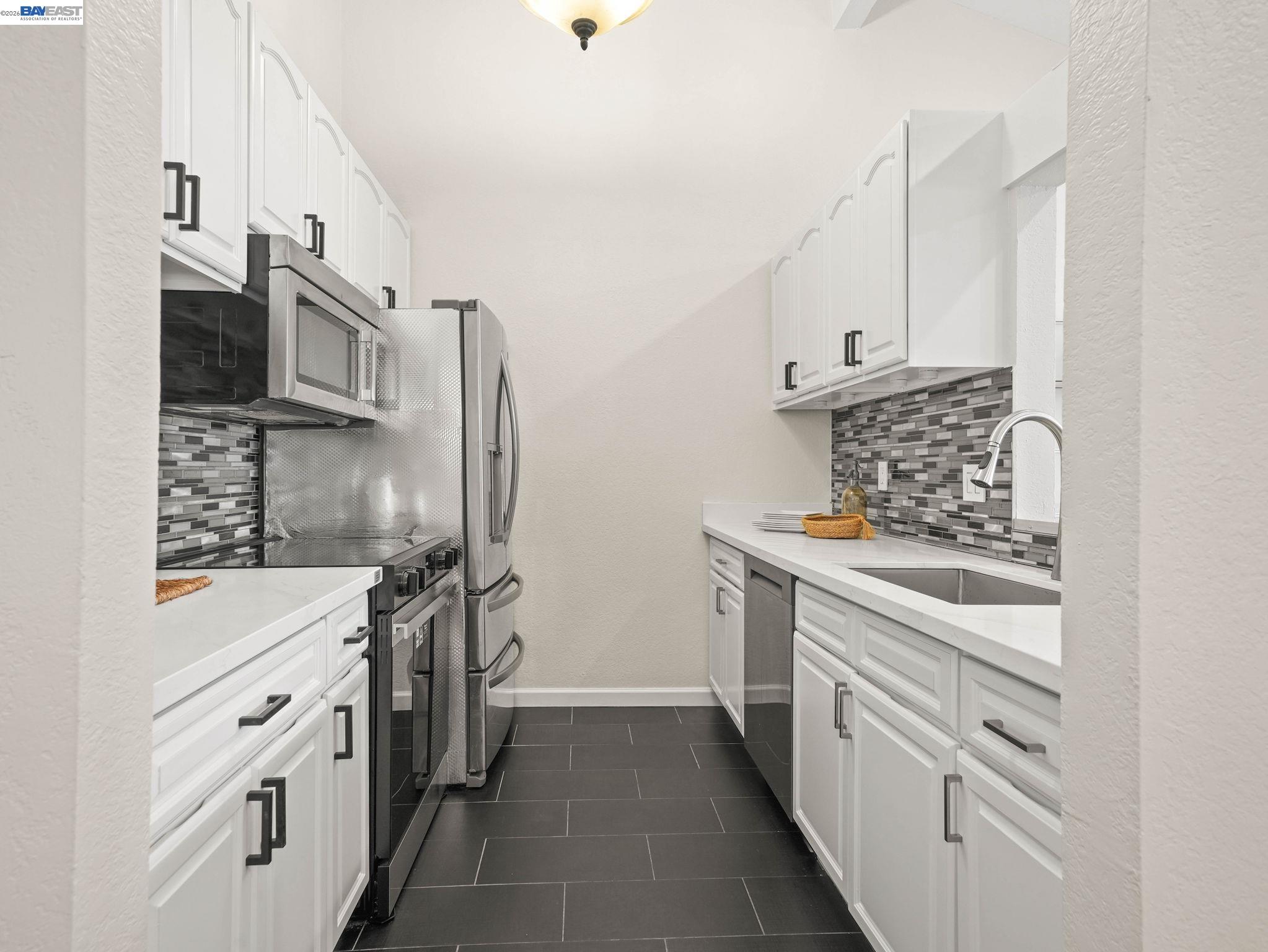 1972 Briscoe Terrace Fremont, CA 94539 - Photo 6 of 27 a kitchen with stainless steel appliances white cabinets and a stove