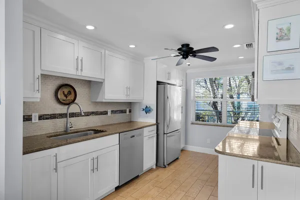 a kitchen with stainless steel appliances granite countertop a sink and a refrigerator
