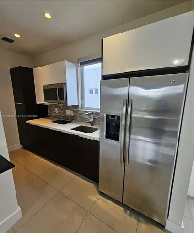 a kitchen with a refrigerator and a sink