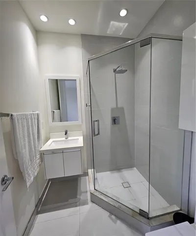 a bathroom with a shower sink and mirror