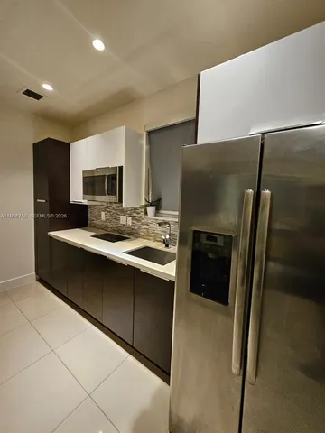 a kitchen with stainless steel appliances a refrigerator and a stove top oven