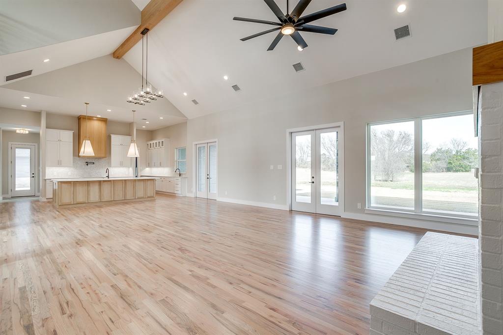 456 Acorn Trail Granbury, TX 76049 - Photo 15 of 40 a view of an empty room with wooden floor and a window