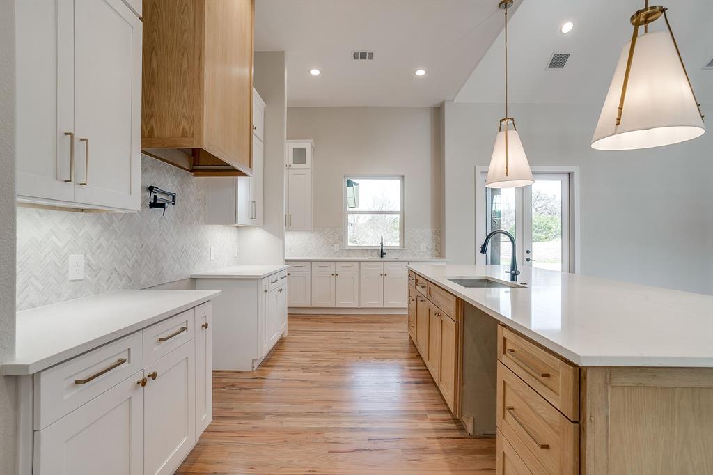 456 Acorn Trail Granbury, TX 76049 - Photo 18 of 40 a large kitchen with stainless steel appliances sink a microwave and cabinets