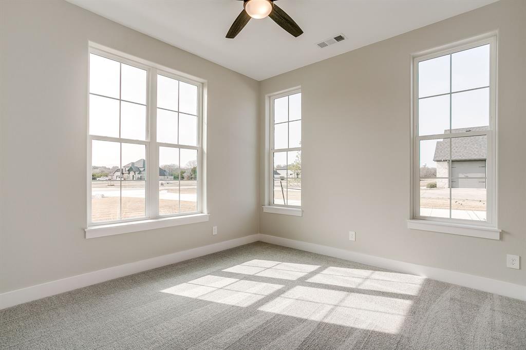 456 Acorn Trail Granbury, TX 76049 - Photo 19 of 40 an empty room with chandelier fan and windows