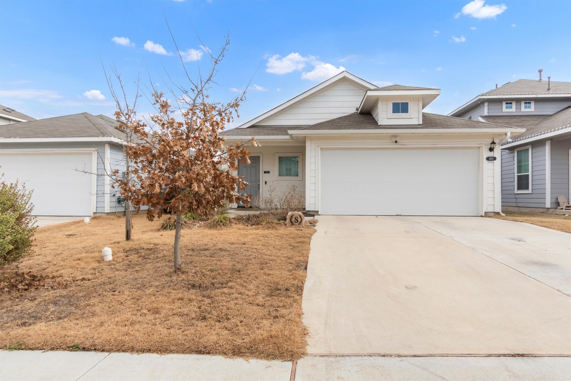 View of front of home featuring driveway, an attached garage, and a porch