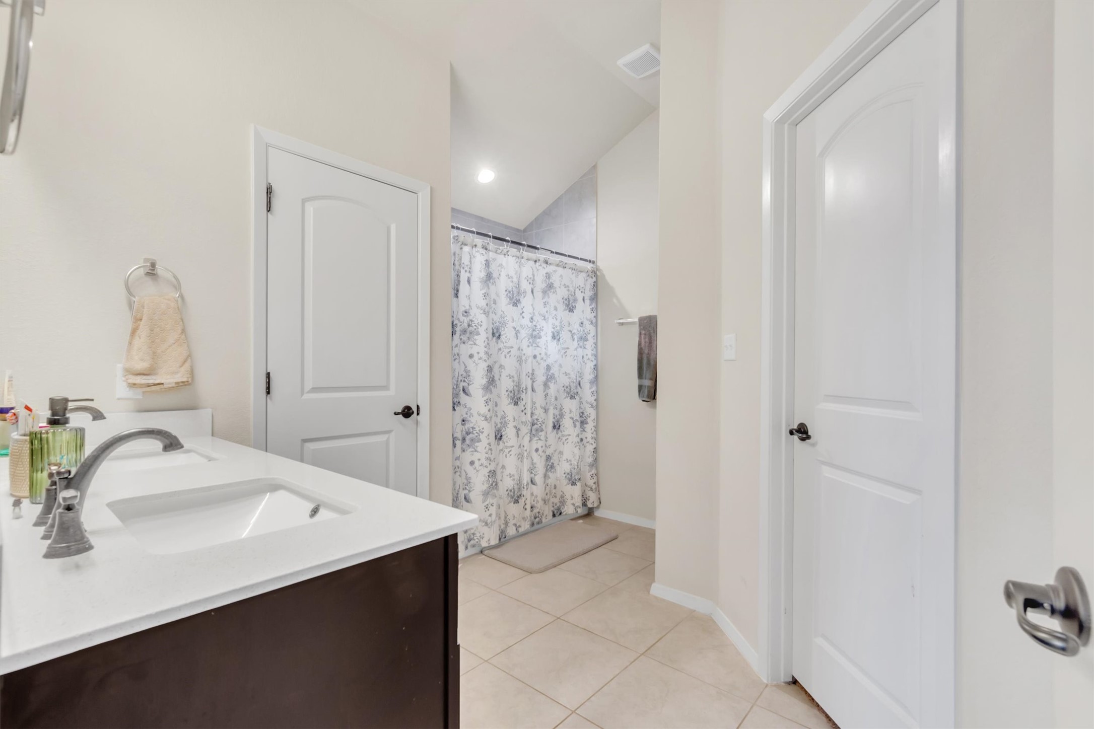 460 Delta Crest Maxwell, TX 78656 - Photo 12 of 18 Full bathroom featuring a shower with shower curtain, double vanity, and light tile patterned floors