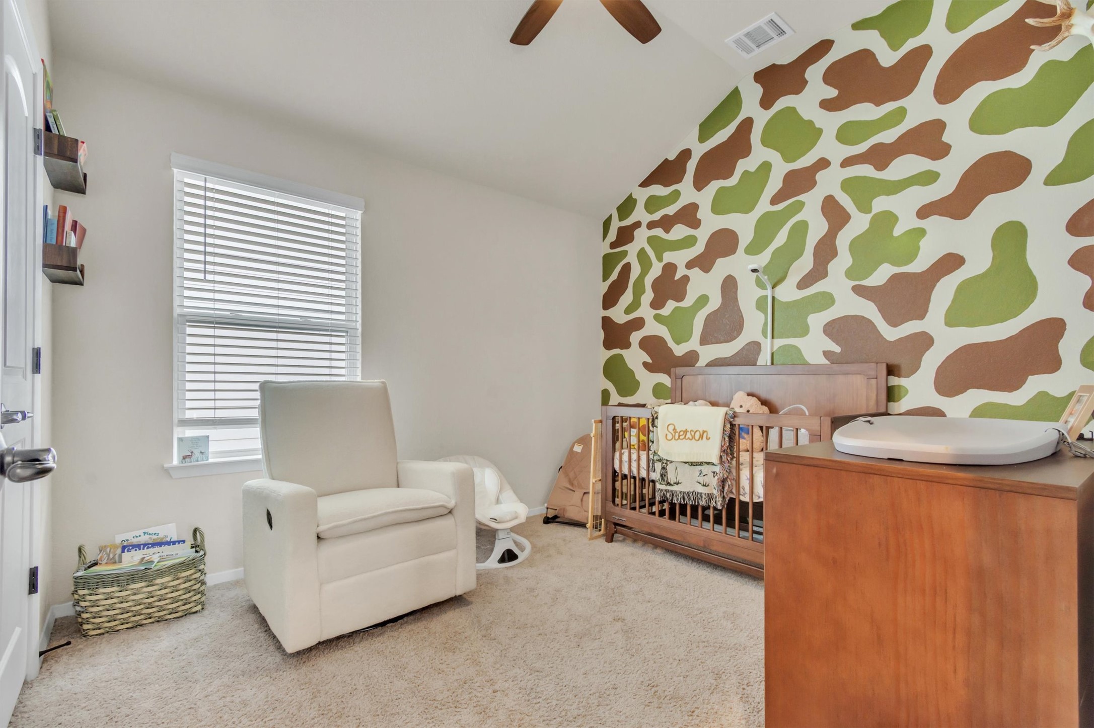 460 Delta Crest Maxwell, TX 78656 - Photo 13 of 18 Bedroom featuring an accent wall, wallpapered walls, a nursery area, carpet floors, and lofted ceiling