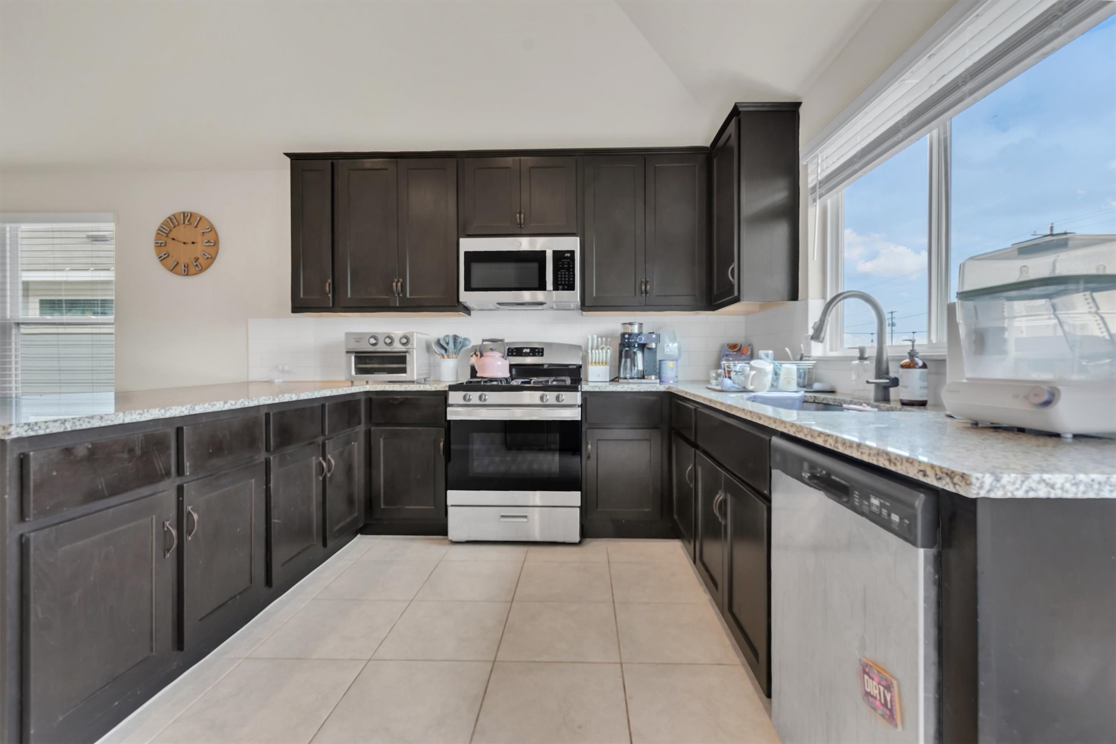 460 Delta Crest Maxwell, TX 78656 - Photo 8 of 18 Kitchen with stainless steel appliances, tasteful backsplash, lofted ceiling, light stone countertops, and light tile patterned floors