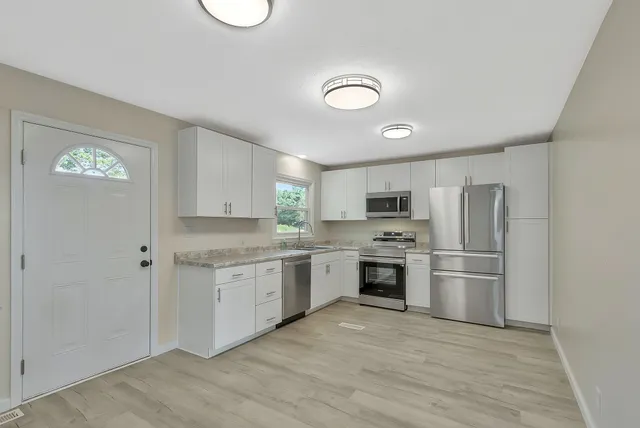a kitchen with a refrigerator sink and stove top oven