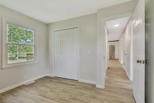 a view of a hallway with wooden floor and a window